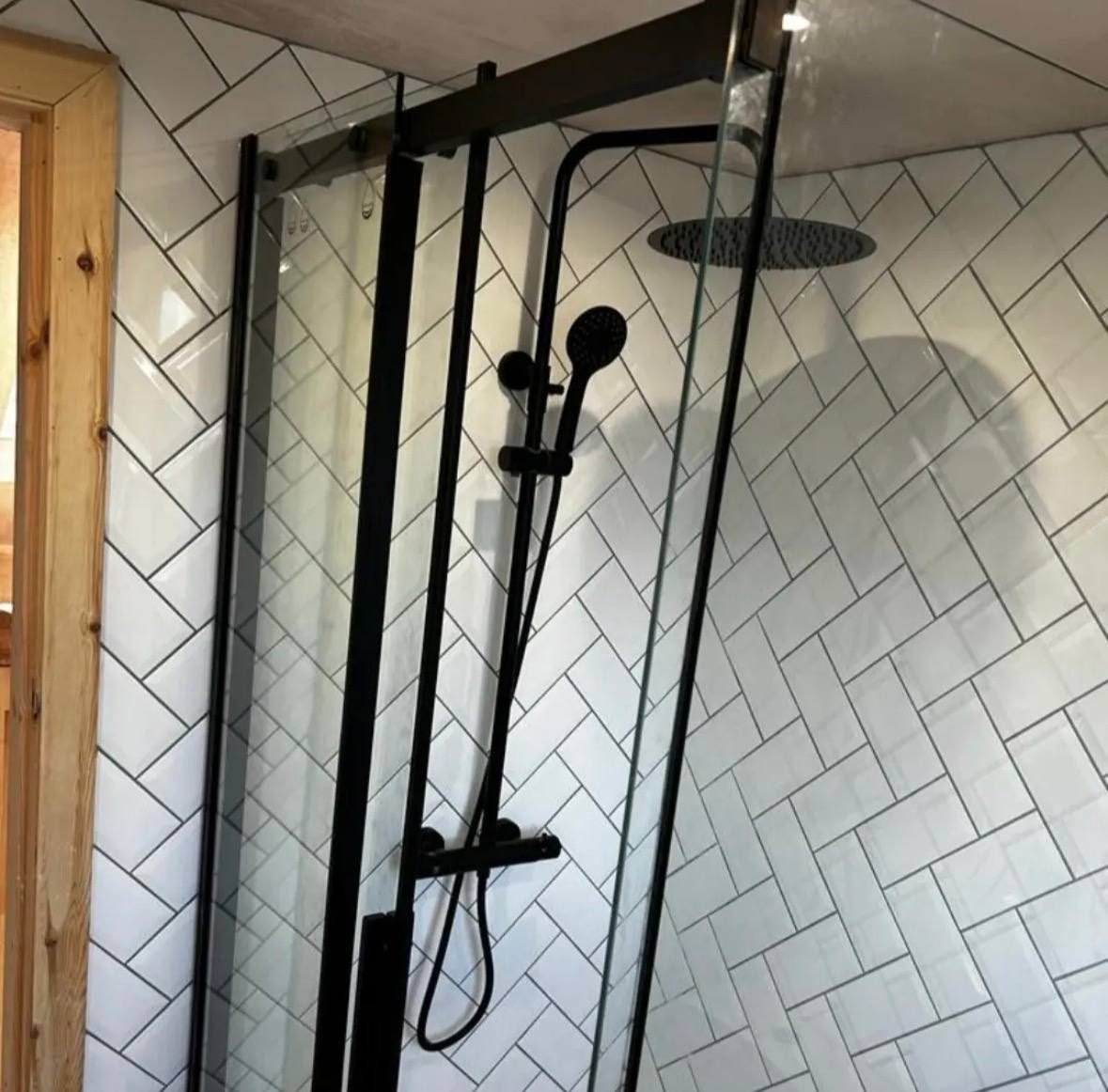 New shower installation with matt black fittings and herringbone tiling